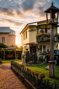 a house with a fence in front of it at Adomo Rojus in Palanga