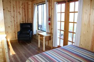 a bedroom with a bed and a chair and a window at Drakesbad Guest Ranch in Chester