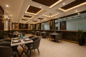 ein Restaurant mit Tischen und Stühlen in einem Raum in der Unterkunft Hotel Platinum Grand Near IGI Airport Delhi in Neu-Delhi + 24 Fotos