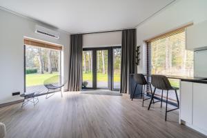 a kitchen and dining room with a table and chairs at Beautiful Tinyhouse near the Beach in Lapmežciems