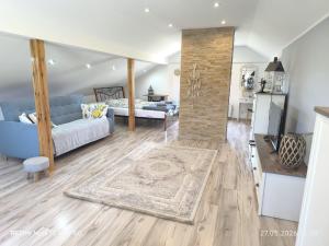 a living room with a couch and a bed in a room at Sielskie Markowskie in Markowskie