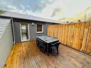 a patio with a table and chairs on a wooden deck at Chez Dubuiss in Houffalize