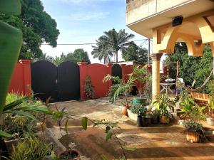 a backyard with a fence and a lot of plants at Au cœur de Ouidah in Ouidah