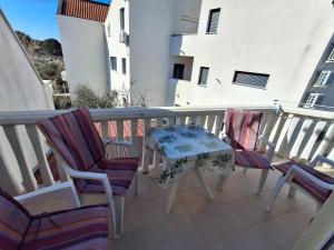 a table and two chairs on a balcony at Mara apartman in Košljun +19 photos