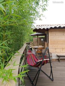 a hammock on the deck of a cabin at Chalet de la Grave in LʼEscarène