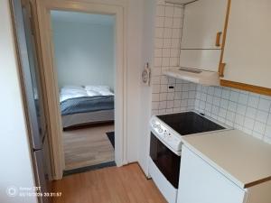 a small kitchen with a bed in a bedroom at Sentrumsnær leilighet in Trondheim