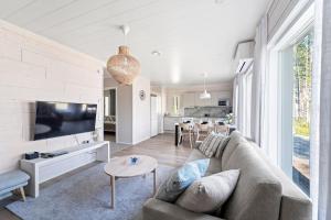 a living room with a couch and a tv at Villa Mustikkaranta Koli, oma ranta in Kolinkylä