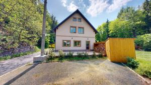 a small house in the middle of a driveway at Apartmány Nová Oleška in Huntířov