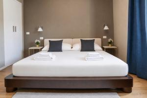 a large white bed in a room with two tables at Due Strade APT - Oltrarno Collection in Florence