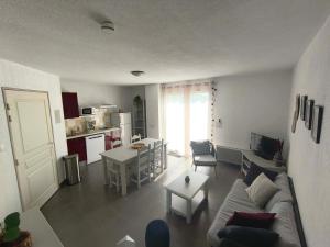 a living room with a couch and a table and a kitchen at Maison Les Demeures du Ventoux in Aubignan