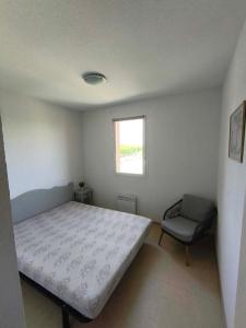 a bedroom with a bed and a chair in it at Maison Les Demeures du Ventoux in Aubignan