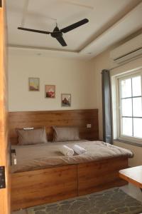 a bedroom with a large bed with a ceiling fan at Aarunya Stays in Rishīkesh