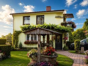 a house with a flower garden in front of it at Adomo Rojus in Palanga