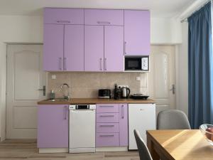 a kitchen with purple cabinets and a table at Apartman Stankovic in Negotin