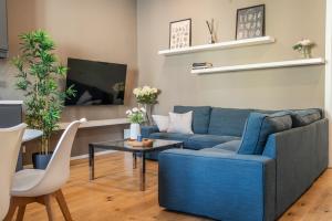 a living room with a blue couch and a table at Due Strade APT - Oltrarno Collection in Florence