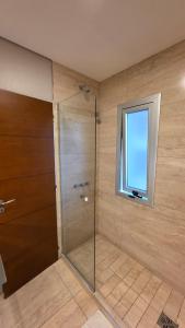 a shower with a glass door and a window at TORRE GUAYASAMIN in Corrientes