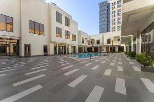 an empty courtyard of a building with a pool at Aswar Hotel in Al Khobar