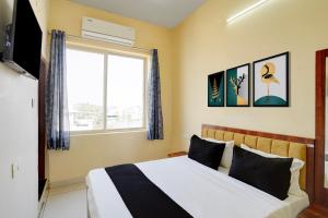 a bedroom with a large bed and a window at Hotel O Peace Inn in Bhopal +57 photos