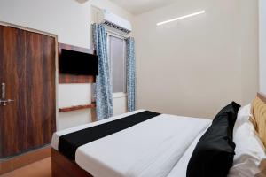 a bedroom with a bed and a television in it at Hotel O Peace Inn in Bhopal