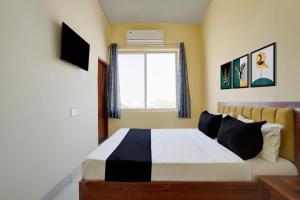 a bedroom with a large bed with a window at Hotel O Peace Inn in Bhopal