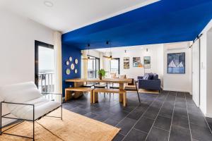 a living room with a wooden table and a blue ceiling at Casa do Porto - Santa Cruz B&B in Ribeiras