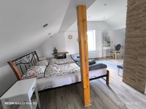 a bedroom with a bed with a wooden post at Sielskie Markowskie in Markowskie