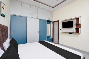 a bedroom with a large bed and a tv at Hotel O The Signature Residency in Rohtak +26 photos