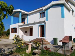 a white house with blue accents at L' Aurora Marina in SantʼAnna Arresi