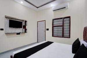 a room with a flat screen tv and a window at Hotel O The Signature Residency in Rohtak