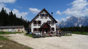 a group of people standing in front of a house at Stanza Cuori Malga Ciauta in Villanova