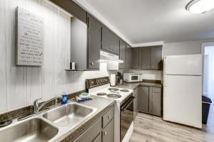 a kitchen with a sink and a refrigerator at Lake Huron Launchpad! Creekfront Condo for Two in Port Huron