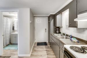 a kitchen with white cabinets and a sink at Lake Huron Launchpad! Creekfront Condo for Two in Port Huron +11 photos