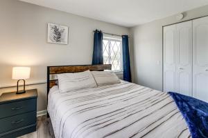 a bedroom with a large bed and a window at Lake Huron Launchpad! Creekfront Condo for Two in Port Huron