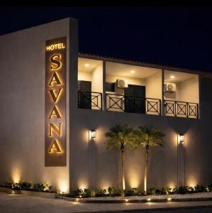 a building with a hotel sign and palm trees at Savana Park Hotel in Andradina