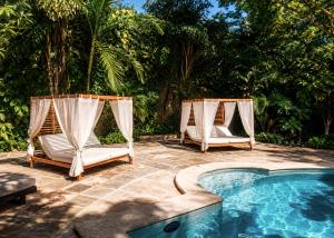 a couple of chairs next to a swimming pool at Villa Merida Luxury Mansion - Adults Only Boutique Hotel in Mérida