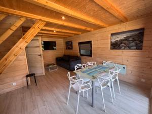 a room with a table and chairs in a cabin at Domki Albertówka - Strefa Relaksu in Ostrowo