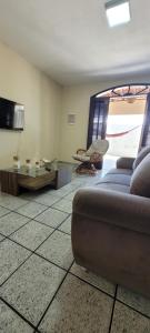 a living room with a couch and a tv at Casa grande com suite in São Luís