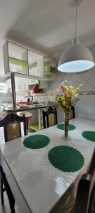 a dining room table with a vase of flowers on it at Casa grande com suite in São Luís