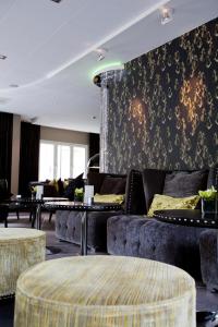 a living room with couches and tables and a wall at Clarion Collection Hotel Tapto in Stockholm