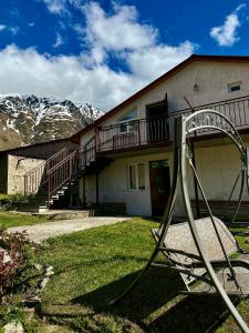 a house with a playground in front of it with mountains at Guest house chavchavadze N23 in Kazbegi