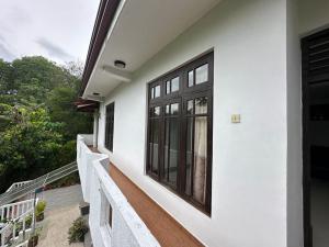 a balcony of a white house with windows at Ceylander Suites in Kandy +6 photos