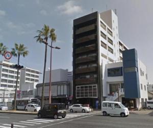 a street with cars parked in front of a building at Comfort CUBE PHOENIX MIYAZAKI in Miyazaki