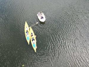 a yellow boat and a white boat in the water at Siedlisko Szwałk in Szwalk