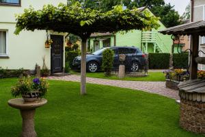a garden with a tree in the middle of a yard at Adomo Rojus in Palanga +6 photos