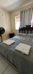 two towels are sitting on top of a bed at Casa grande com suite in São Luís