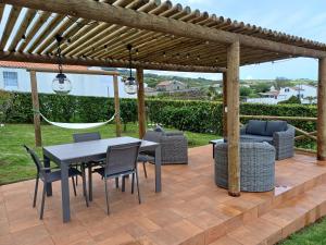 a patio with a table and chairs under a pergola at Casa do Galante in Nordeste