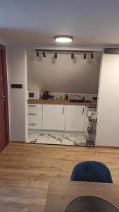 a kitchen with white cabinets and a table at Giżycko WP30 in Giżycko +4 photos