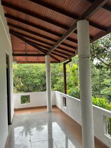 a porch with a wooden roof and columns in a house at Ceylander Suites in Kandy