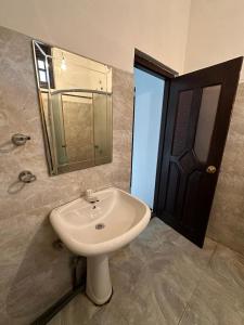 a bathroom with a white sink and a mirror at Ceylander Suites in Kandy
