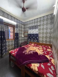 a bedroom with a bed with a purple blanket on it at ROGHAY COTTAGE in Matheran